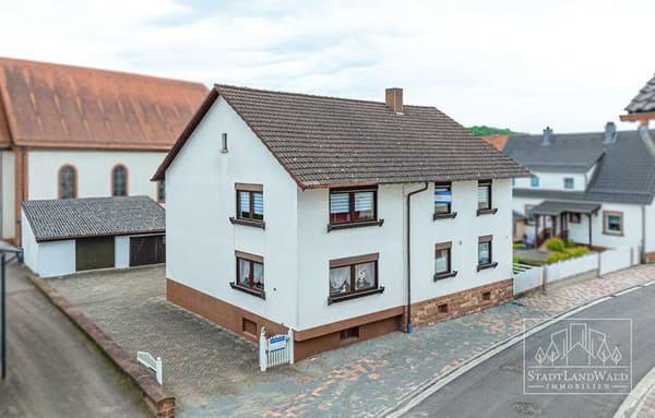 Immobilie in Fischbach bei Dahn - Wohnen, vermieten, weiterdenken – Solides Zweifamilienhaus mit Garten und Garagen im Ortskern - Bild 1